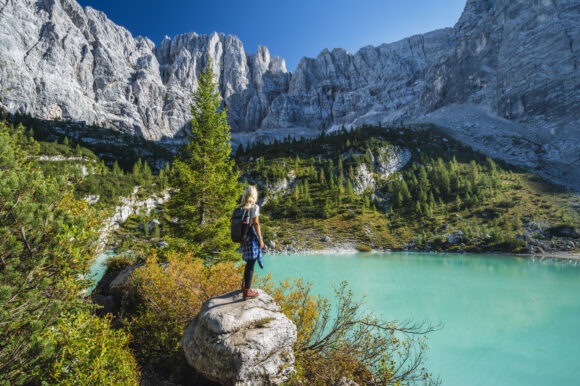 Woman hiker enjozing beautifulturquoise mountain Sorapiss lake in Dolomites, Italy